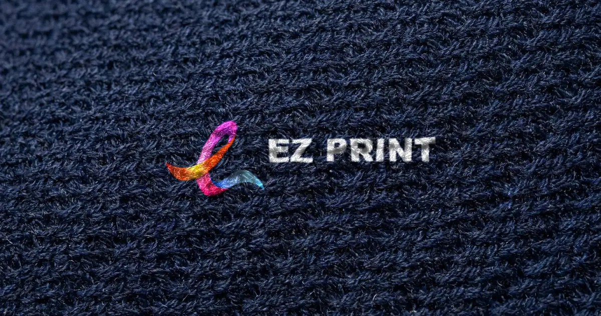 Close-up of navy knitted polo fabric with the EZ Print logo printed on it.