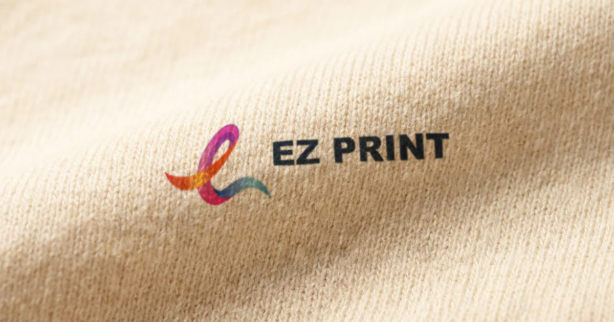 Close-up of cream cotton jersey printed with the EZ Print logo.