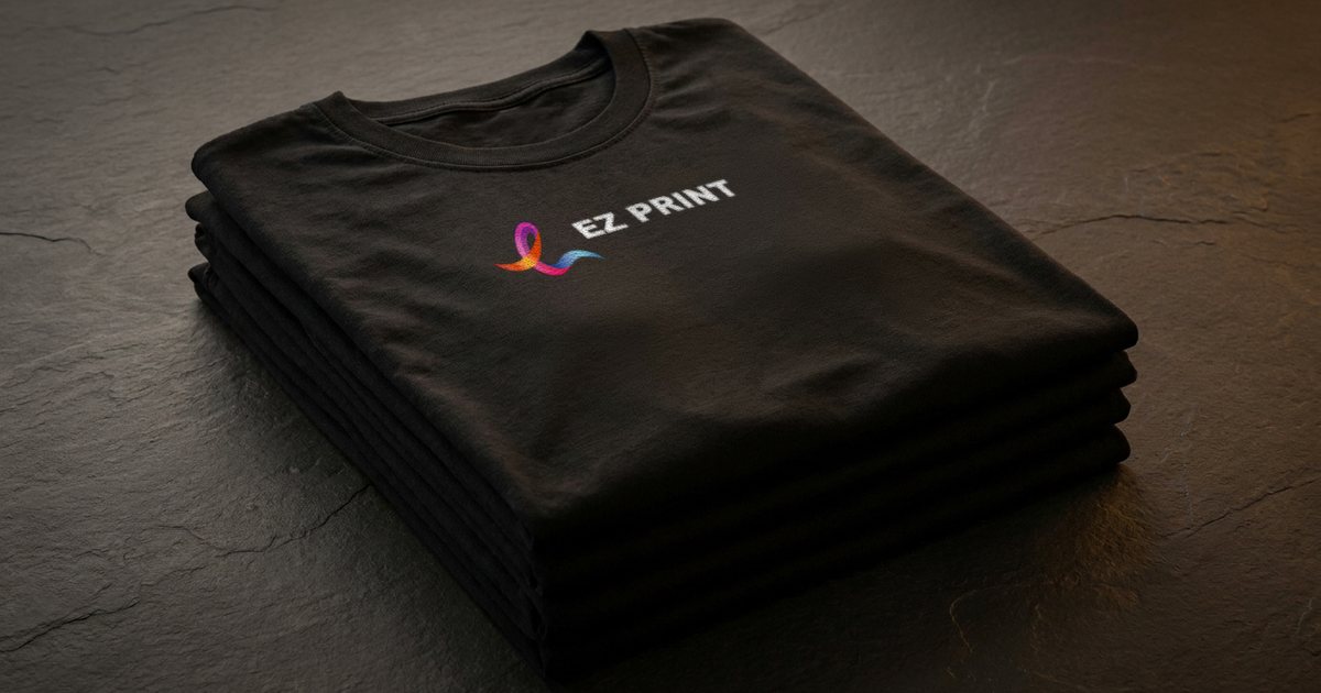 A stack of folded black T-shirts with the EZ Print logo printed across the chest of the top shirt.