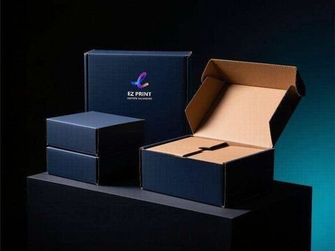 Navy mailer boxes, the standing one printed with the EZ Print ribbon mark, beside an open kraft-lined mailer box.